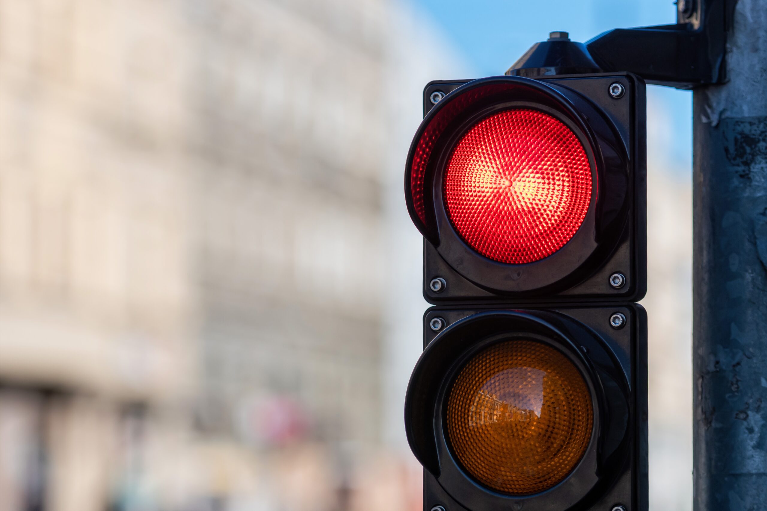 closeup of traffic semaphore with red light on defocused city street background with copy space
